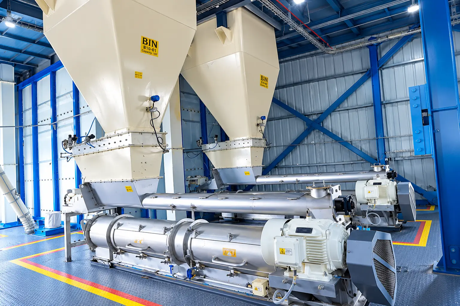 Overhead dosing bins and feed screws above the Quarit processing line